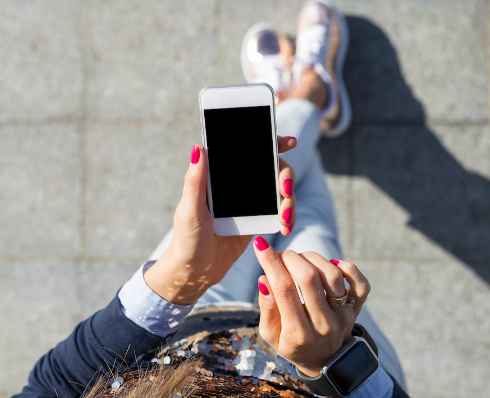 Woman walking with a cellphone in her hand